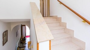 Un escalier avec une rampe en bois et des marches en marbre.