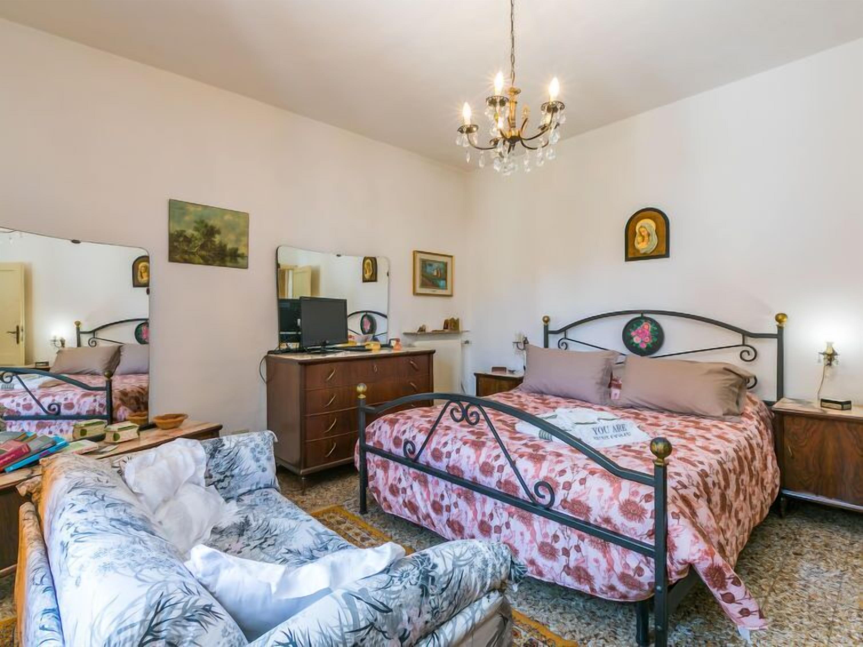 Un dormitorio con cama, cómoda, escritorio y silla.