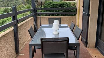 Relax in style on this serene patio surrounded by lush greenery and distant hills, with a glass-top table and comfortable seating for six.