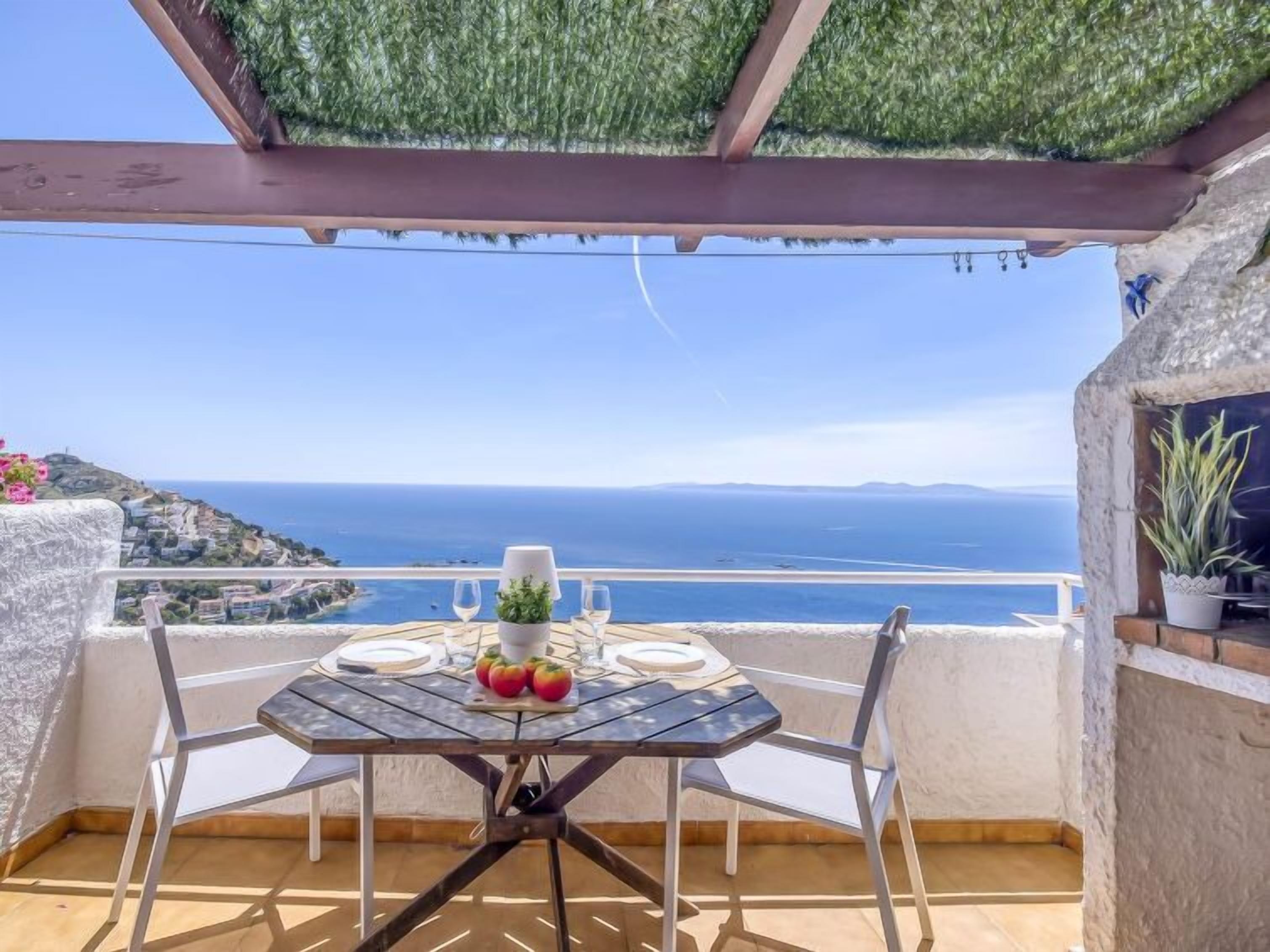 A table set for two with a view of the sea and distant land.