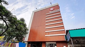 A tall building with a red facade and a sign that reads "Nursing Home". - Hotel FNG Metro View (Noida)