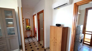 Una cocina con refrigerador, aire acondicionado y un armario de madera.