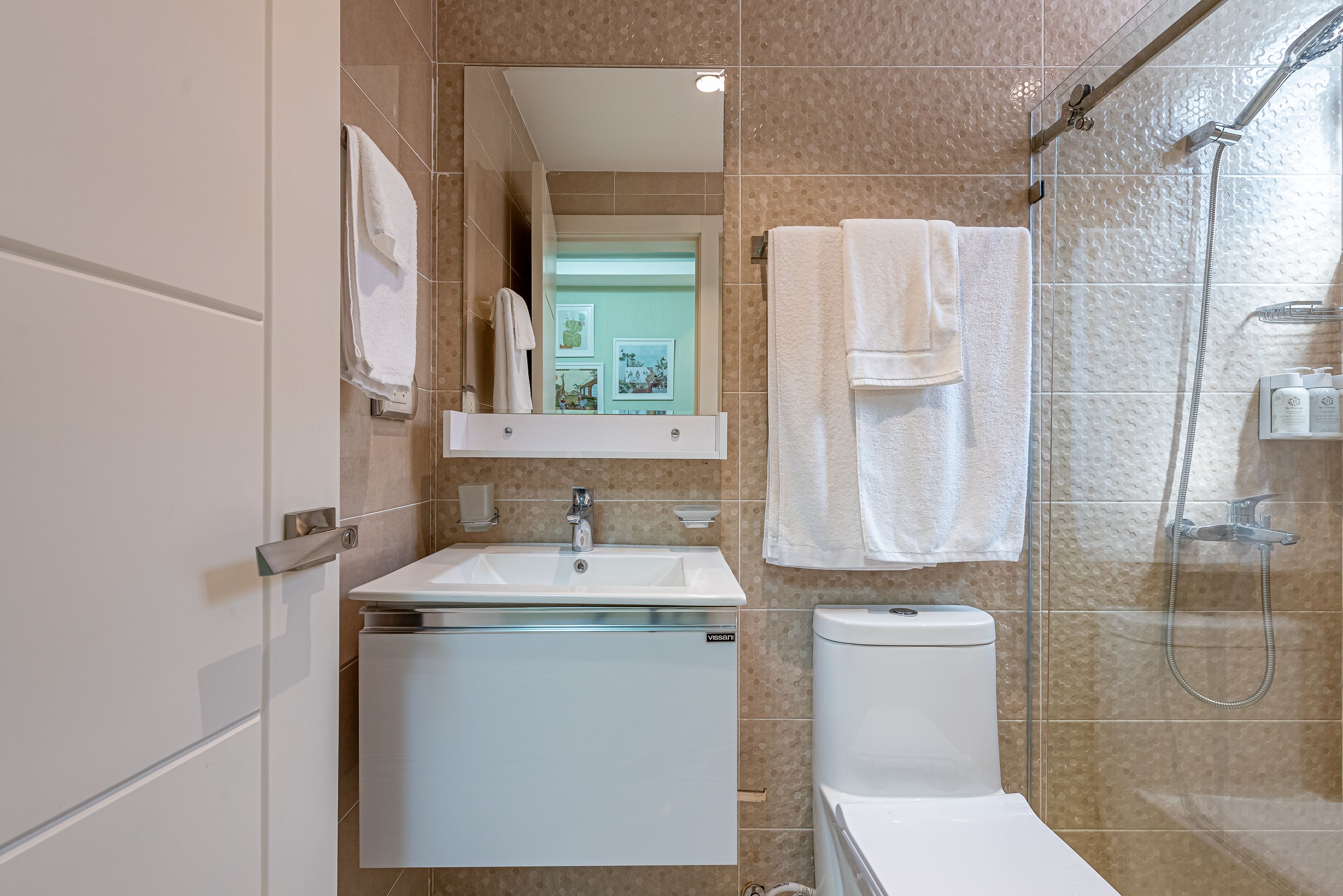 A modern bathroom with a sink, mirror, and toilet.