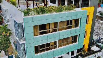 Un edificio de varios pisos con techo plano, terrazas y balcones.