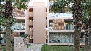 A modern building with a central tower, multiple balconies, and a sign reading "Loft 8D". - Herdade dos Salgados, T3 8D-0B, Vila das Lagoas (Albufeira)