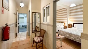 Une chambre d’hôtel équipée d’un lit, de tables de chevet, d’une chaise et d’un extincteur.