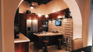 Eine Küche mit Kochinsel, Edelstahlgeräten und einer Backsplash aus Ziegelsteinen.