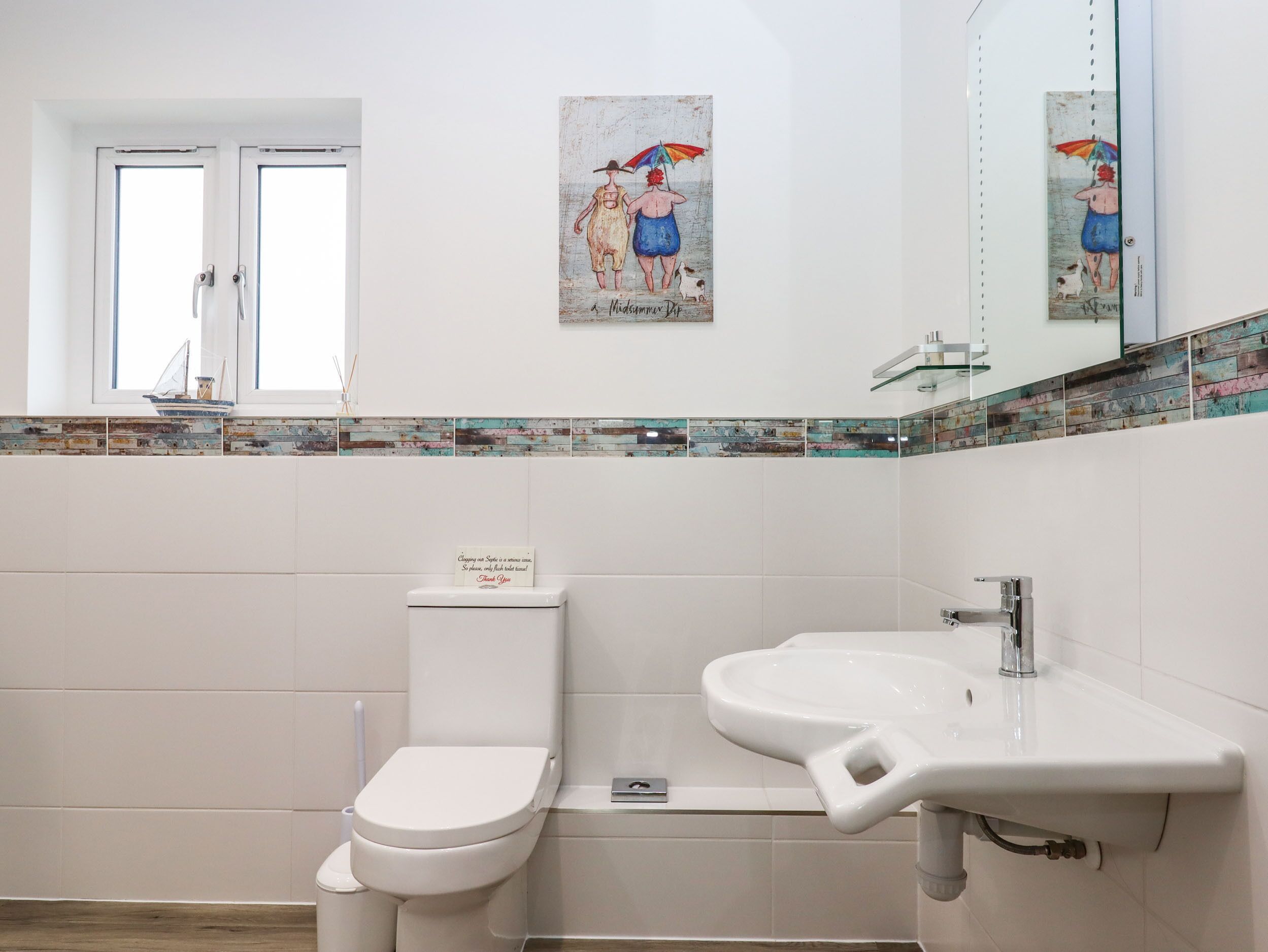 Une salle de bain moderne équipée de toilettes, d’un lavabo et d’un revêtement mural décoratif en carreaux.