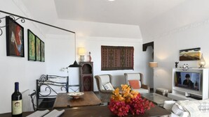 A living room with a sofa, a television, a dining table with a vase of flowers, and a wine bottle. - Casa Saskia with view to Avocado plantation and Atlantic.
Heated Poolarea (La Matanza de Acentejo)