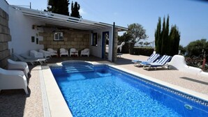 A swimming pool with lounge chairs and a covered seating area. - Casa Saskia with view to Avocado plantation and Atlantic.
Heated Poolarea (La Matanza de Acentejo)