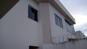 A modern building with two windows and a barbed wire fence. - Apartment, Bairro Santa Lúcia, covered garage 2.50x4.70 (Montes Claros)