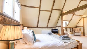 Une chambre confortable avec un lit en bois, une lampe de chevet et un téléviseur.