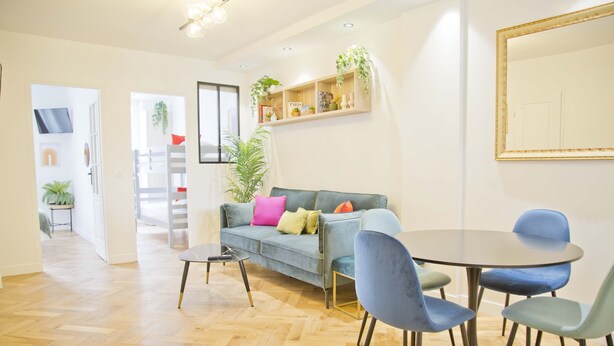 A modern living room with a sofa, chairs, a coffee table, and a bookshelf. - Trendy familly apt in Mouffetard (Paris)