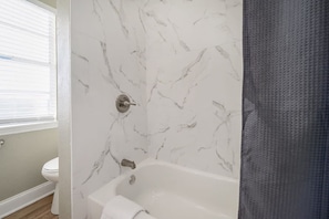 Bathtub, hair dryer, towels, toilet paper