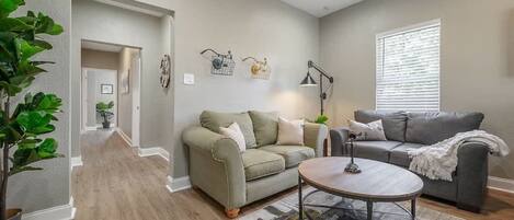 A living room with two sofas, a coffee table, and a potted plant.