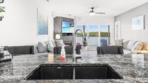 Una cocina moderna con encimera de granito, un lavabo y vistas al exterior.