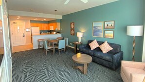 A compact living space with a kitchenette, a dining area, and a seating area with a sofa and chairs. - Seaside Resort - 1 Bedroom 1 Bath - Assignment 1 (Seaside)