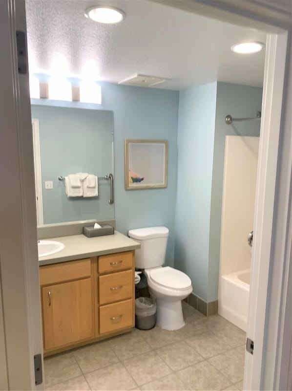 Un baño con inodoro, lavamanos y tocador.