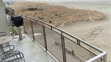 Uma varanda com vista para a praia e montanhas.
