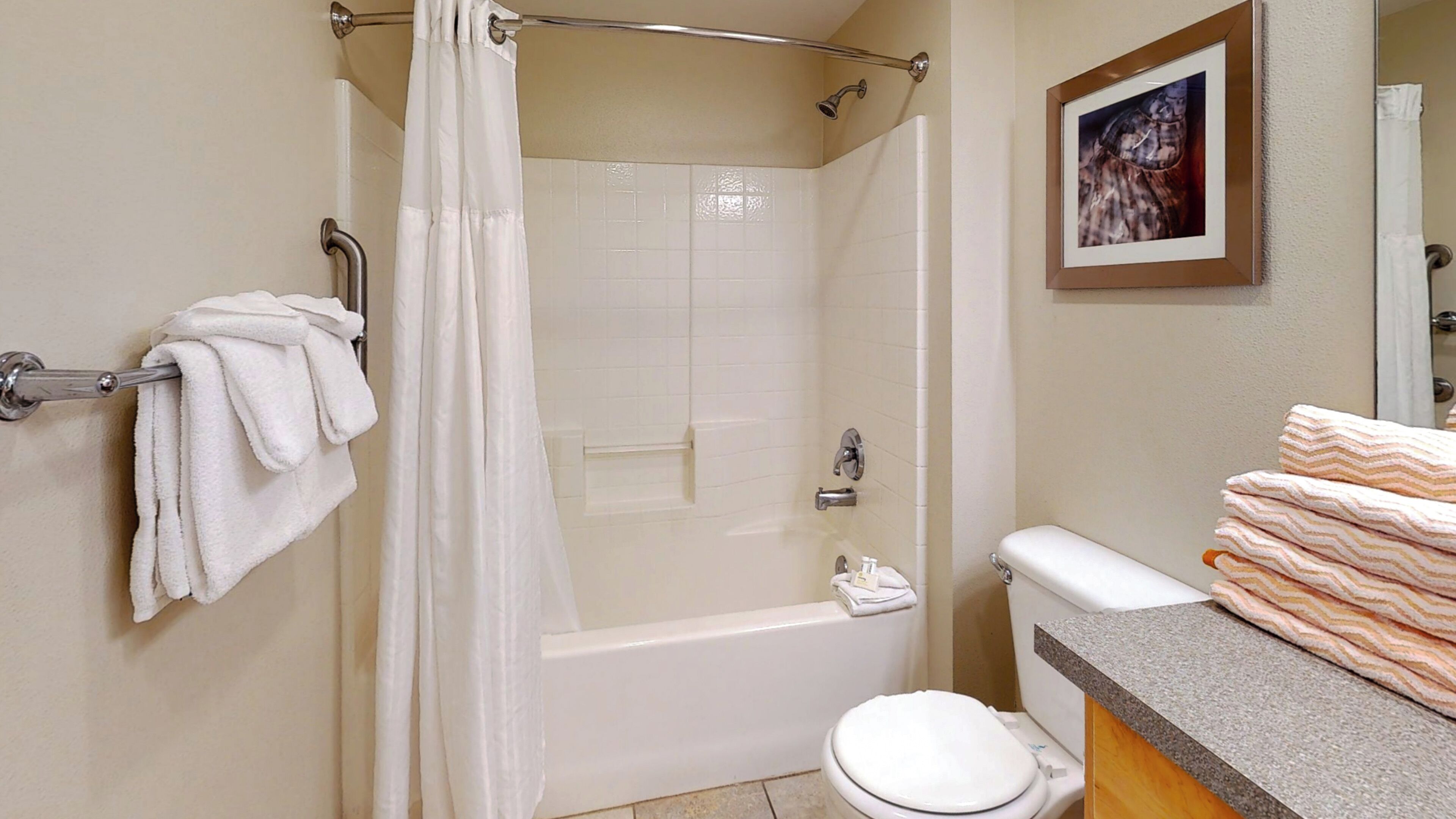 Une salle de bain avec une douche, des toilettes et un porte-serviettes.