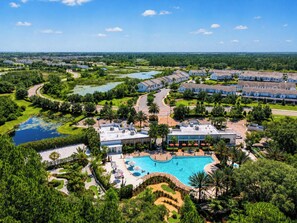 A resort with a swimming pool, guest rooms, and a golf course.
