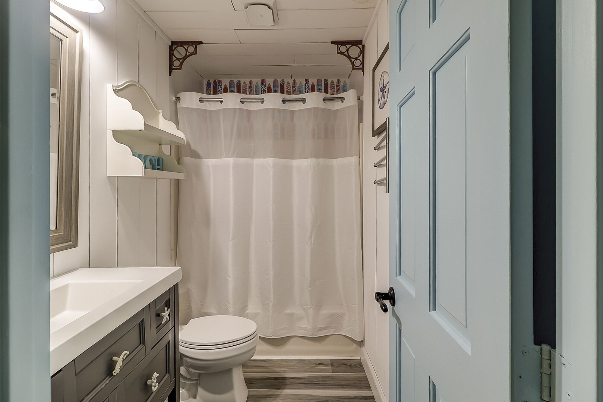 A bathroom with a white toilet, a shower curtain, and a door with a handle.
