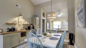 Una cucina moderna con sedie azzurre, un tavolo da pranzo e un lampadario.