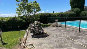 A swimming pool with a surrounding fence, a hose, and a flower bed. - Mas Provençal du XIX Siècle (Cavaillon)
