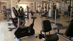 A gym with various exercise equipment including treadmills, stationary bikes, and weight machines.