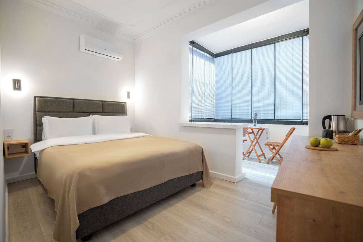 Ein modernes Schlafzimmer mit einem Bett, einem Nachttisch und einem Fenster mit Jalousien.