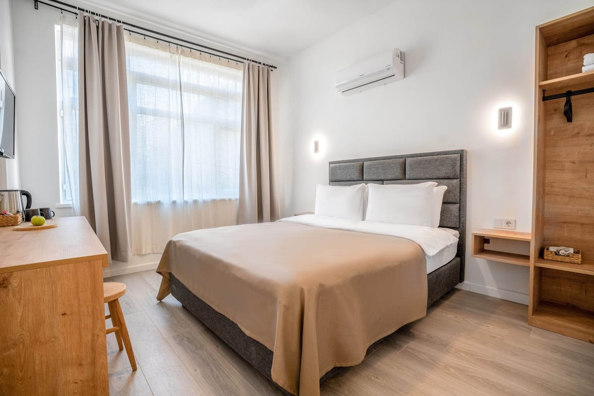 Ein modernes Schlafzimmer mit einem Bett, einem Holztisch und einem Regal.