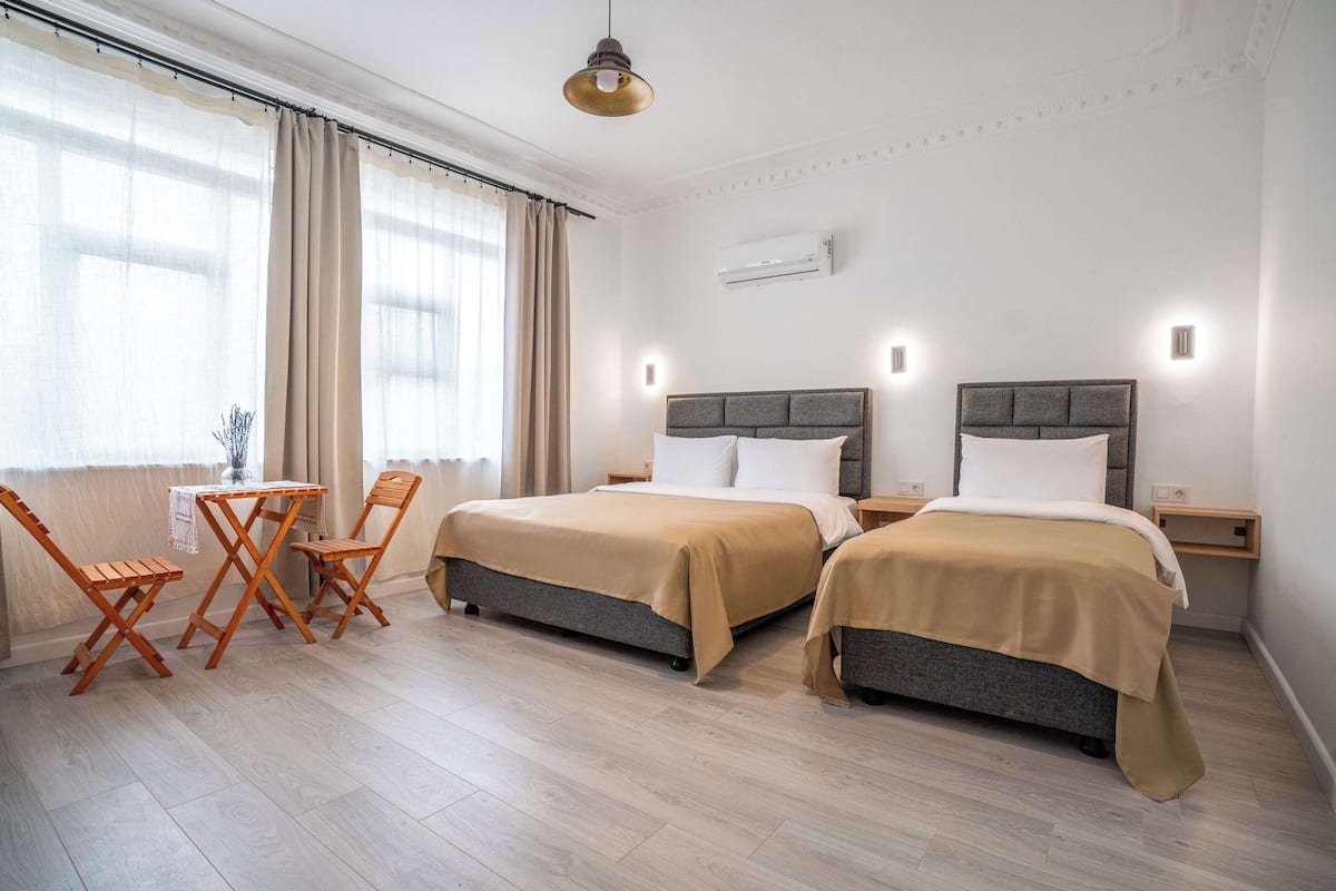 Ein Hotelzimmer mit zwei Betten, einem kleinen Tisch und Stühlen.