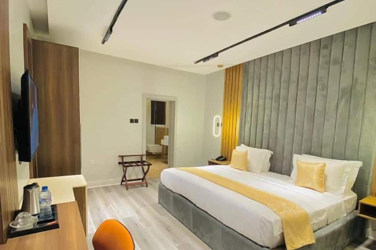 Une chambre d’hôtel moderne, équipée d’un lit, d’un bureau et d’une chaise.