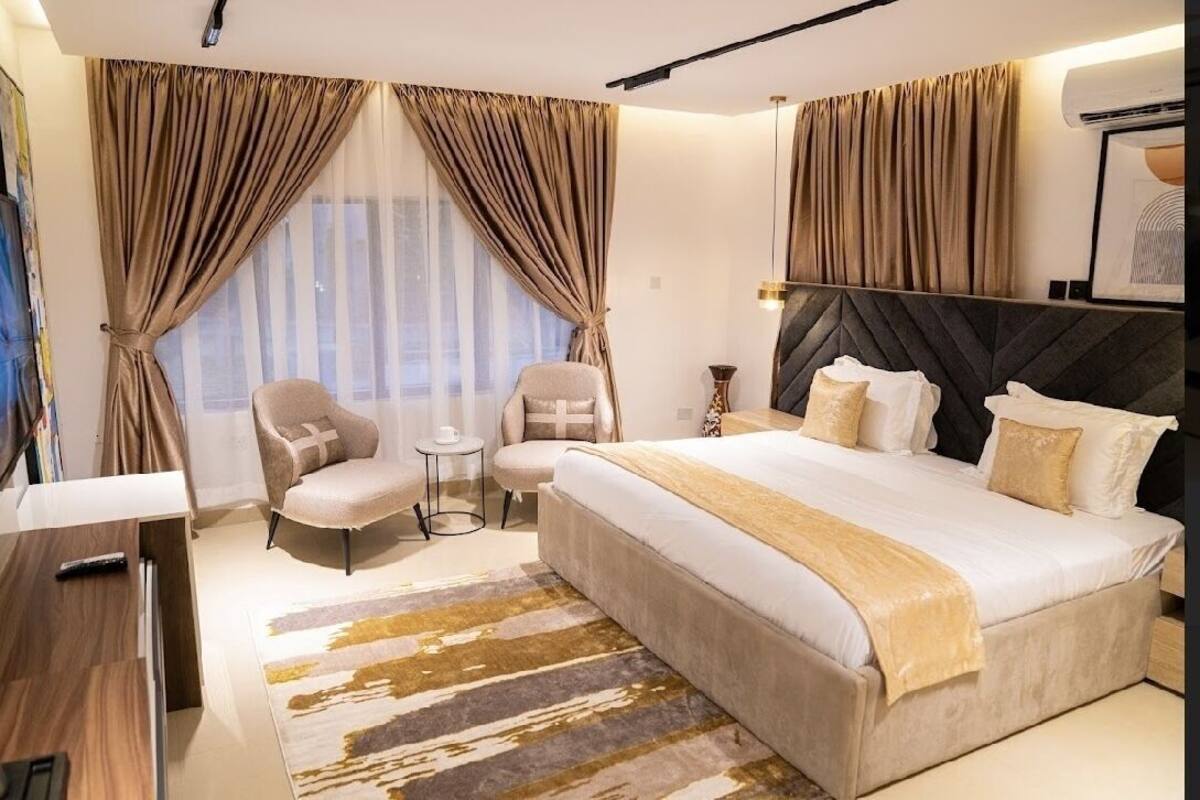 Une chambre d’hôtel moderne équipée d’un grand lit, d’un bureau, d’une chaise et d’une petite table.