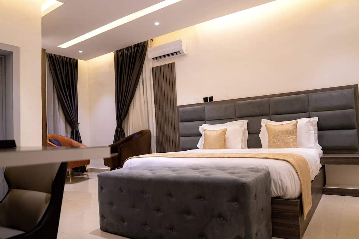 Une chambre d’hôtel moderne dotée d’un grand lit, d’un coin salon et d’un système de climatisation.