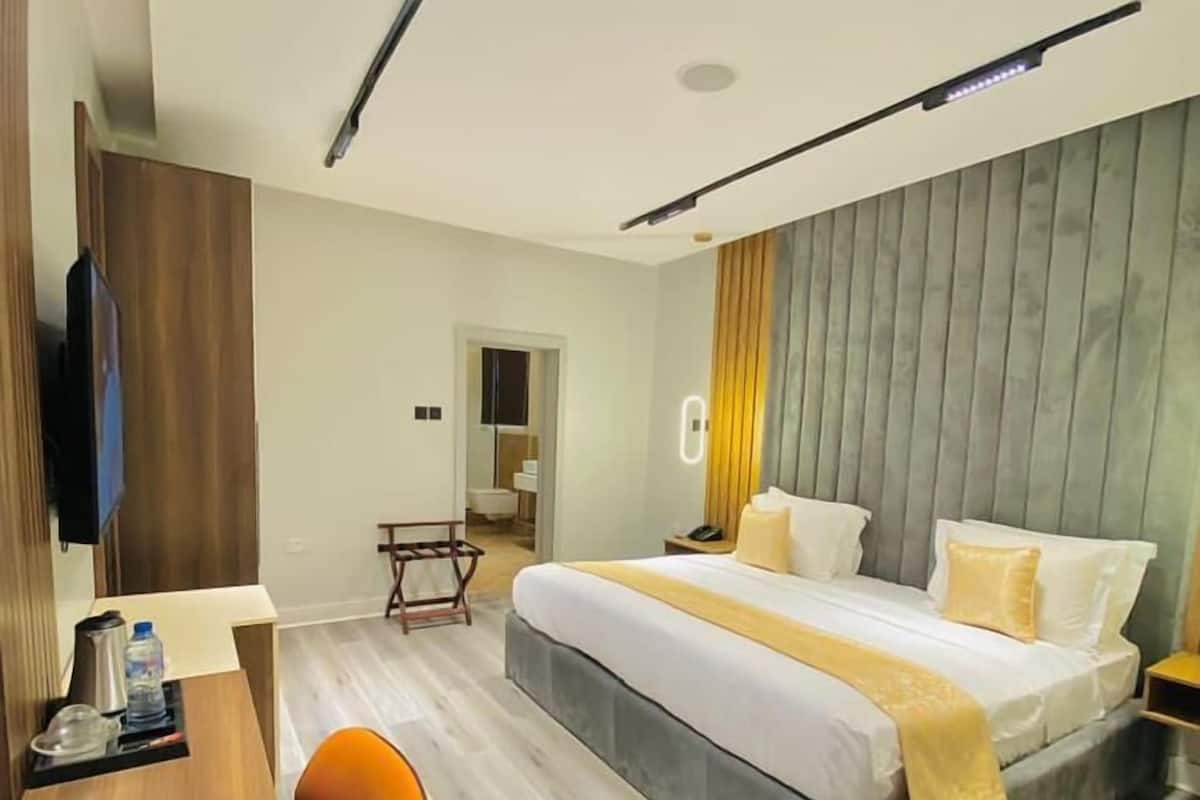 Une chambre d’hôtel moderne, équipée d’un lit, d’un bureau et d’une chaise.