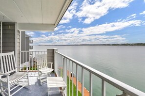 Relax on the balcony with unobstructed views of the calm body of water.