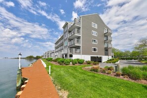 Residents enjoy balconies and scenic views of the adjacent water from a wooden boardwalk.