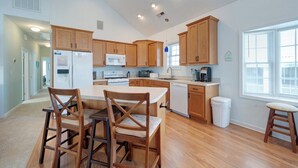 Une cuisine spacieuse avec des meubles en bois, un îlot central et une vue sur l’extérieur.