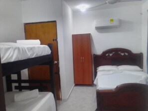 A small, compact room with a bunk bed, a wardrobe, and a single bed.