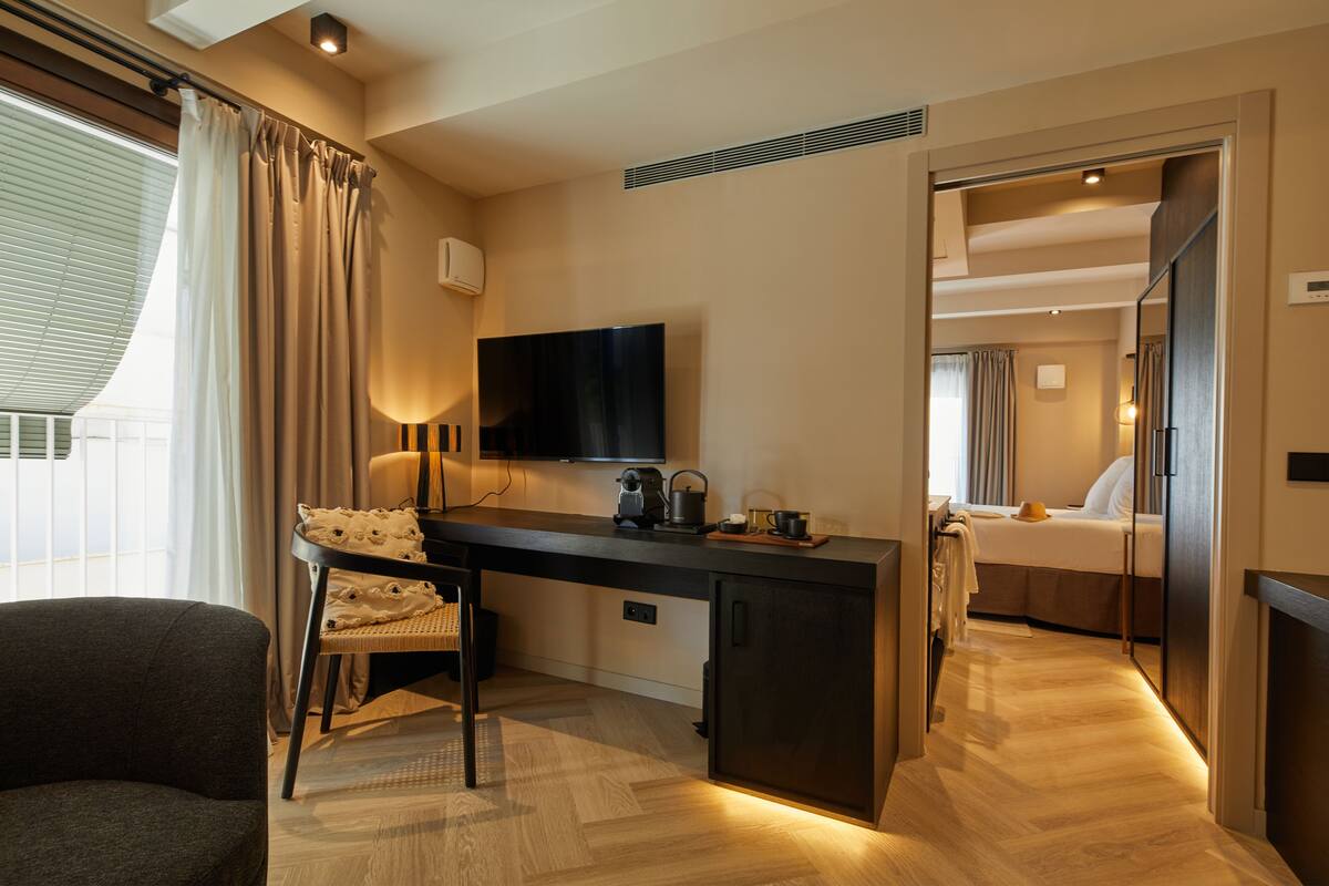 Ein Hotelzimmer mit Schreibtisch, Stuhl und Bett.