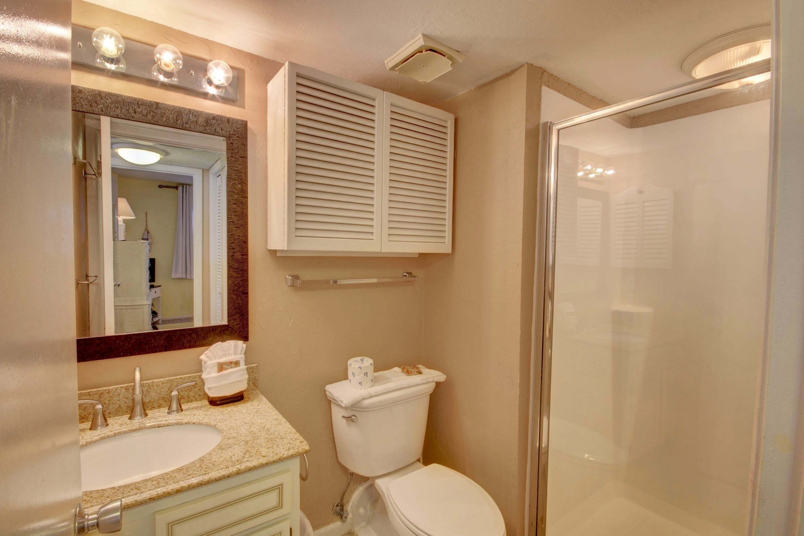 Une salle de bain avec un lavabo, des toilettes et une douche.