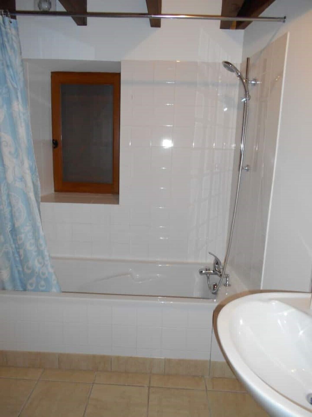 Een badkamer met een bad, een douche en een wastafel.