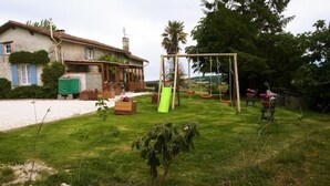 A house with a garden, including a swing set and a green slide. - Le Calme, a cozy studio for two. (Nanteuil Auriac de Bourzac)