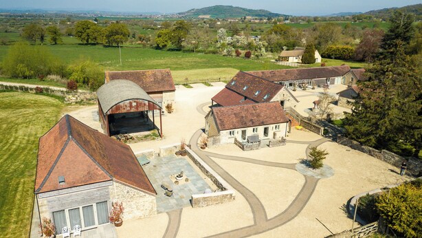 Un vaste domaine comprenant plusieurs bâtiments, notamment une grange, un espace abrité et plusieurs habitations.