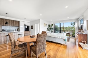 Une cuisine moderne avec un coin repas, de grandes fenêtres et un balcon offrant une vue dégagée.
