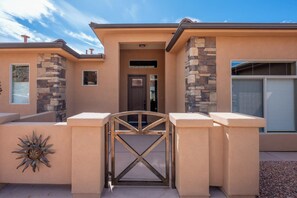 A residential building with a gated entrance, stone accents, and a garage door.