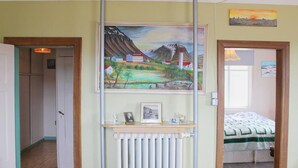 A bedroom with a bed, a radiator, and a painting above the bed. - Old Authentic Icelandic Farmhouse (Laugar)