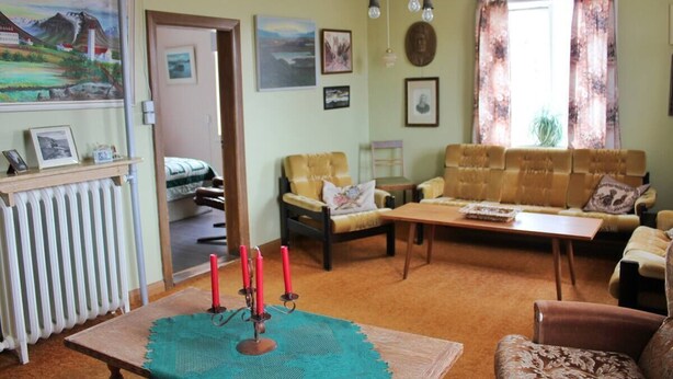 A cozy living room with a sofa, armchairs, a coffee table, and a fireplace. - Old Authentic Icelandic Farmhouse (Laugar)