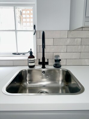 Enjoy cooking in this well-equipped kitchen with a stainless steel sink and modern appliances.
